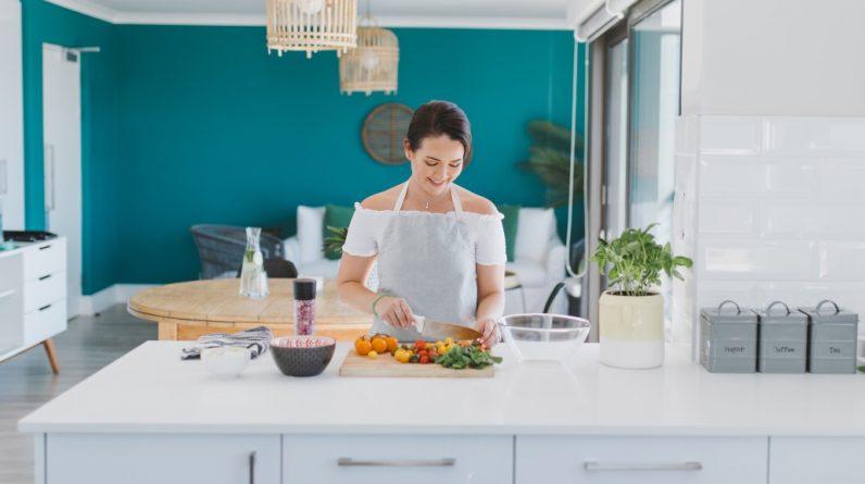 A woman is detoxifying her way to health and beauty as she prepares food in a kitchen.